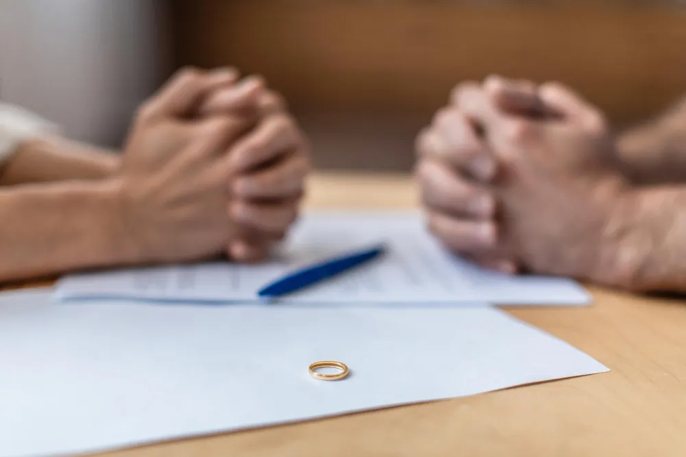Mãos entrelaçadas sobre documentos, simbolizando divórcio com filhos menores.