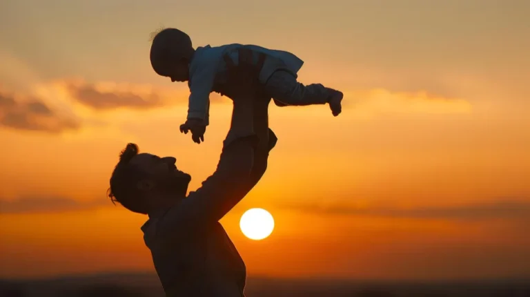 Pai erguendo bebê ao pôr do sol, tema de pensão alimentícia para filhos maiores de idade.