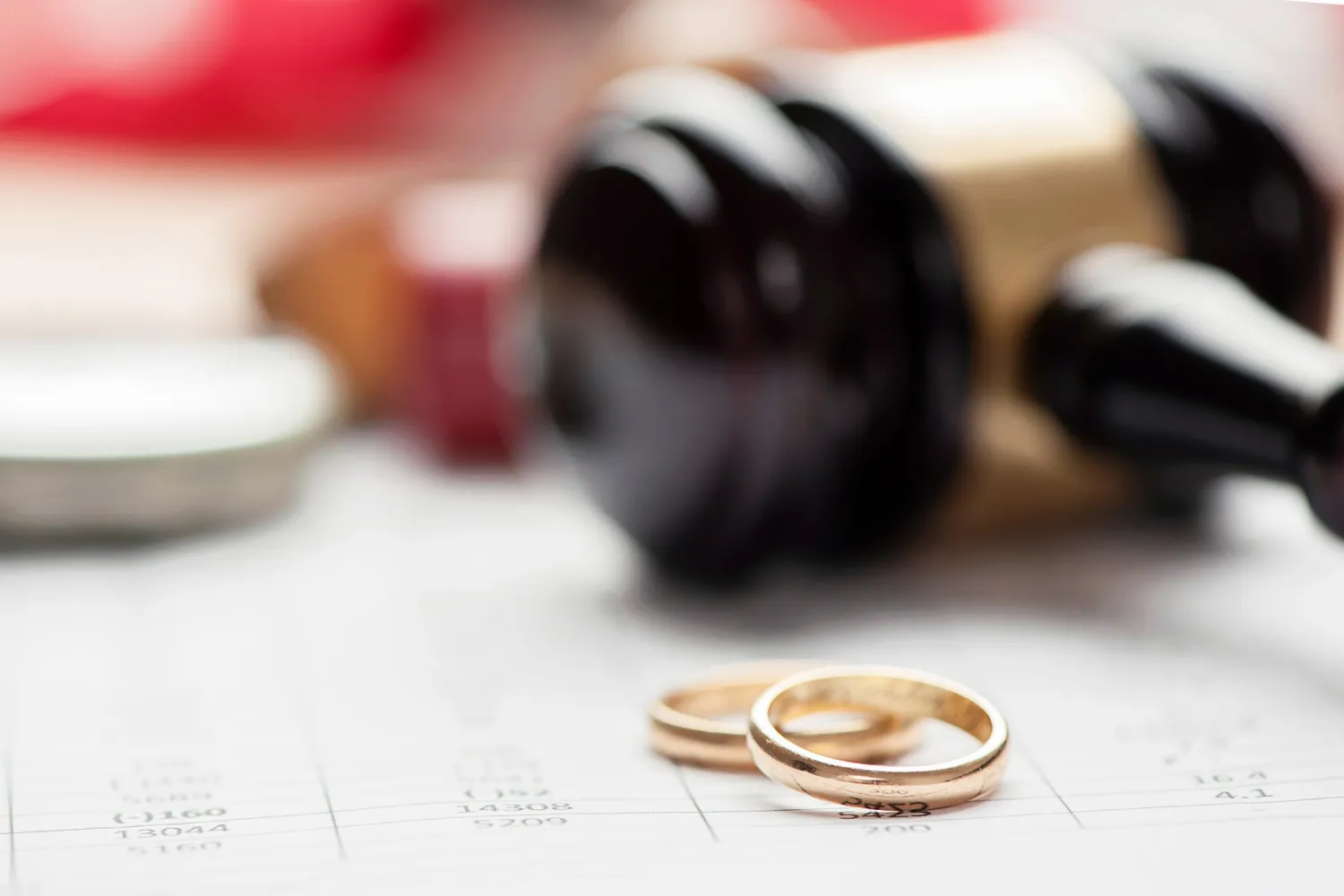 Aliança de casamento e martelo de juiz em caso de divórcio com violência doméstica.