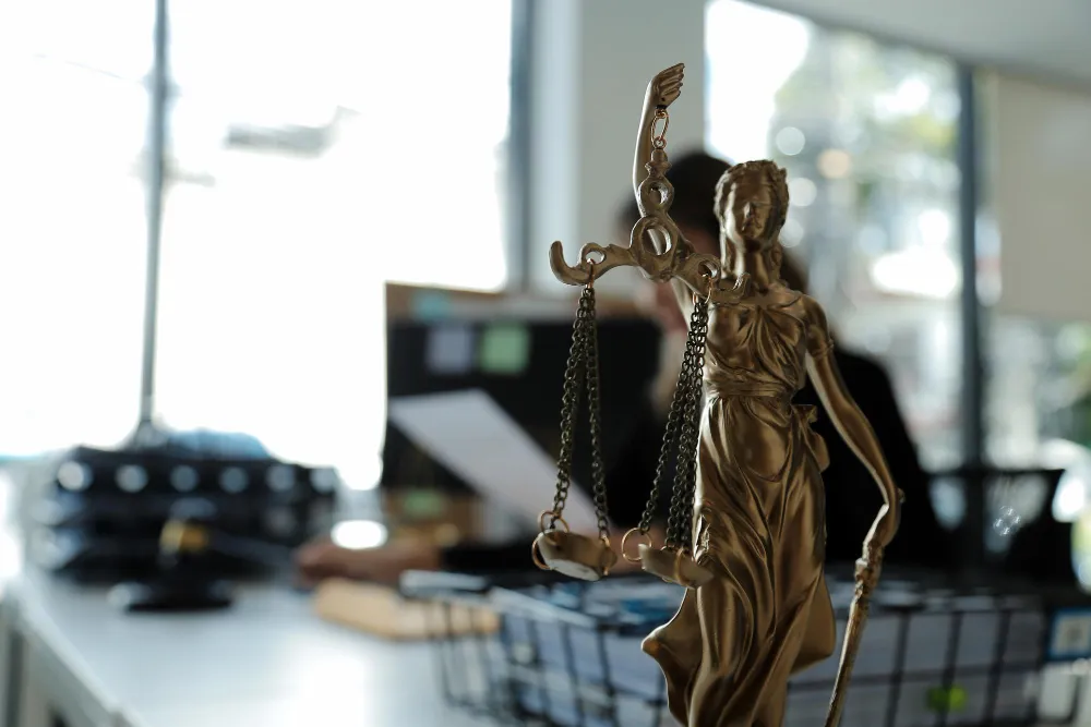 Estátua da Justiça em escritório, simbolizando pedido de guarda compartilhada.
